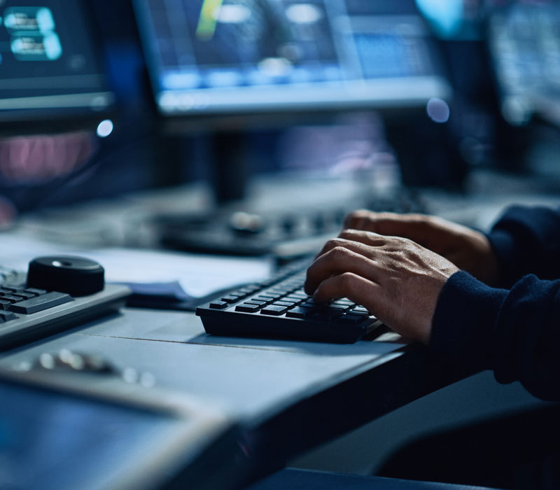 man typing on keyboard in security center