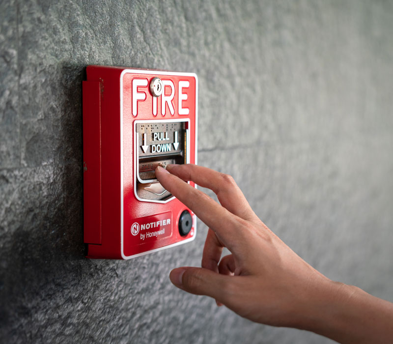 person demonstrating how to pull commercial fire alarm