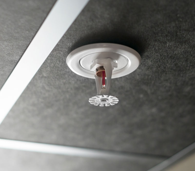 closeup of fire sprinkler on ceiling of commercial building